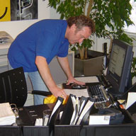 A man bends over while cleaning an office
