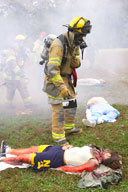 A fire fighter looking over multiple victims
