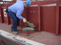 Barge void space hatch being opened or closed