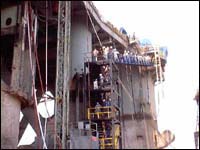 Workers exiting vessel during evacuation drill.