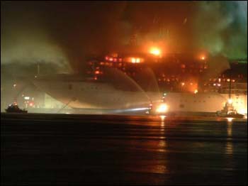 Vessel on fire being extinguished by fireboats.