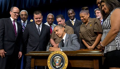 Secretary of Labor Thomas E. Perez (left) watches as President Barack Obama signs the Fair Pay and Safe Workplace executive order on July 31, 2014.