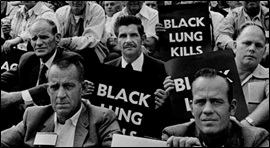People holding Black Lung Kills posters