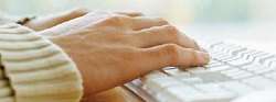 Hands typing on computer keyboard
