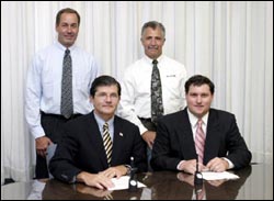 Back Row, (left to right), Curtis Ruppert, Regional Manager, BELFOR USA and Rusty Aramante, Director of Training and Implementation, BELFOR USA. Front Row, (left to right), OSHA's then-Assistant Secretary, John Henshaw, and Paul Becker, Corporate Safety Manager, BELFOR USA.