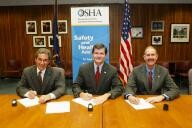 (Seated left to right) Bruce N. Scholnick, President and CEO, NWPCA, OSHA's then-Assistant Secretary of Labor, John Henshaw, and Dr. John Howard, Director, NIOSH, sign the OSHA/NWPCA/NIOSH Alliance.