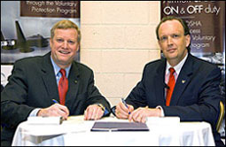 Edwin G. Foulke, Jr., former Assistant Secretary of Labor, OSHA (left) and William C. Anderson, Assistant Secretary of the Air Force, Installations, Environment and Logistics, sign a partnership agreement between the Air Force and Occupational Safety and Health Administration on August 27, 2007 in Washington, D.C. at the annual Voluntary Protection Programs Participants' Association Conference.