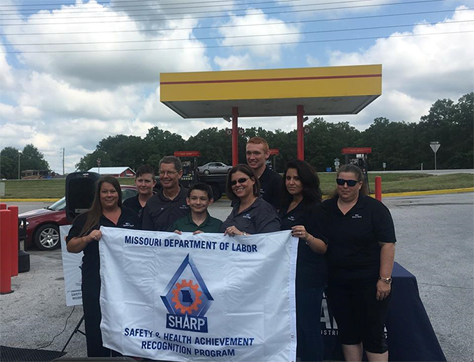 Holding the SHARP Flag, from Left to Right:  Michelle Larkowski - Assistant Manager; Patt Langston - Cashier; Bill Spurlock - Owner; Aaron Collins - Cashier; Linda Collins - Vice President; Tommy Velier - Cashier; Erica Zavala – Cashier; and Jennifer Joh