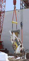 AMWTF Project, April 1, 2002 (Supercompactor Lift): The 62-ton supercompactor was rigged for a two-crane lift before being placed through the roof of the Treatment facility by a 220-ton crane.