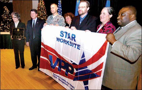 Taylor, Parker and Spacy are joined by Cynthia Bryant, VPP program manager, James Womack, Karin Getschow, and Anthony Cohn to receive the VPP flag.