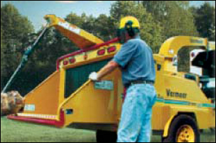 Worker standing next to a chipper