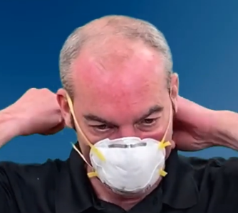 Man adjusting protective face mask