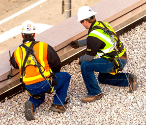 Roofing workers wearing proper fall protection systems.